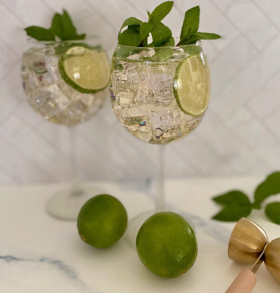 2 Hugo spritz glasses with limes and jigger