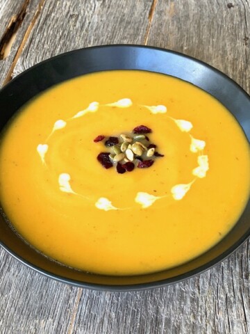 bowl of butter nut squash soup with garnishes