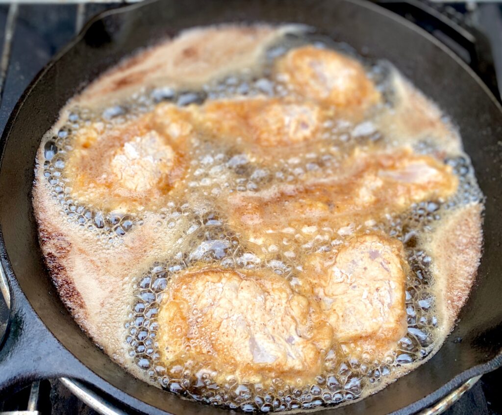chicken frying in pan