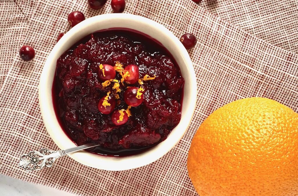an orange and a bowl of cran sauce