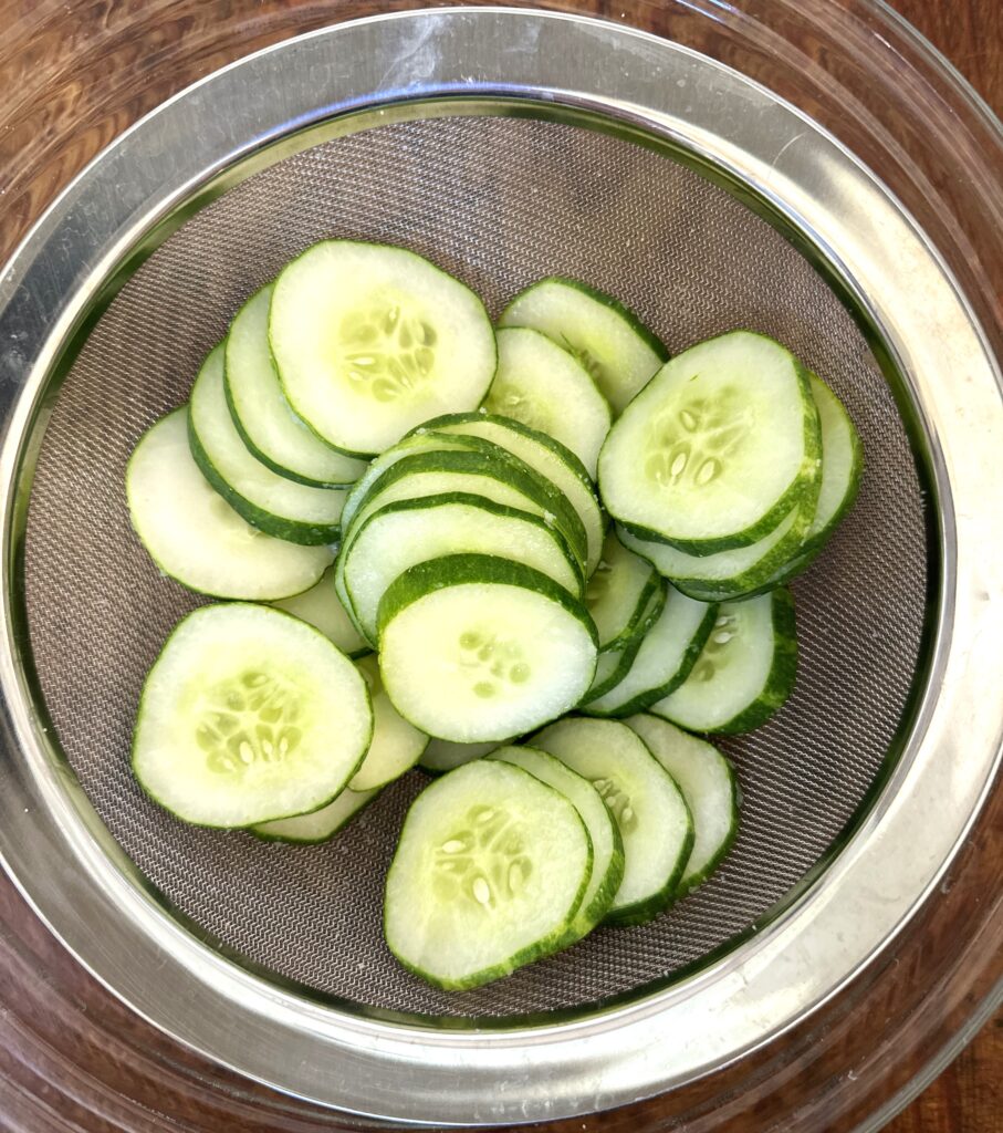 salted cucumbers in sieve