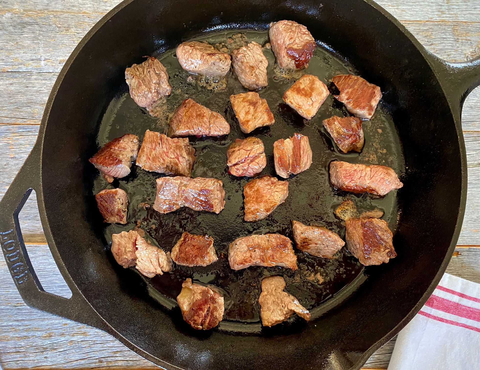 Pieces of beef cooked in cast iron pan