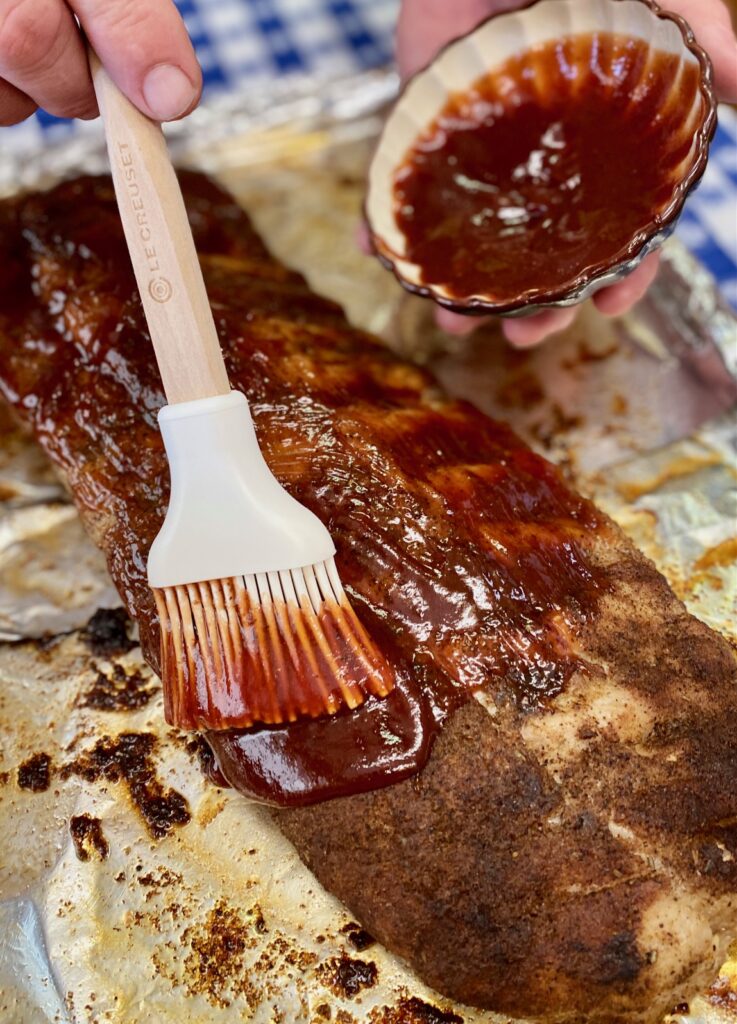 Ribs getting slathered with bbq sauce