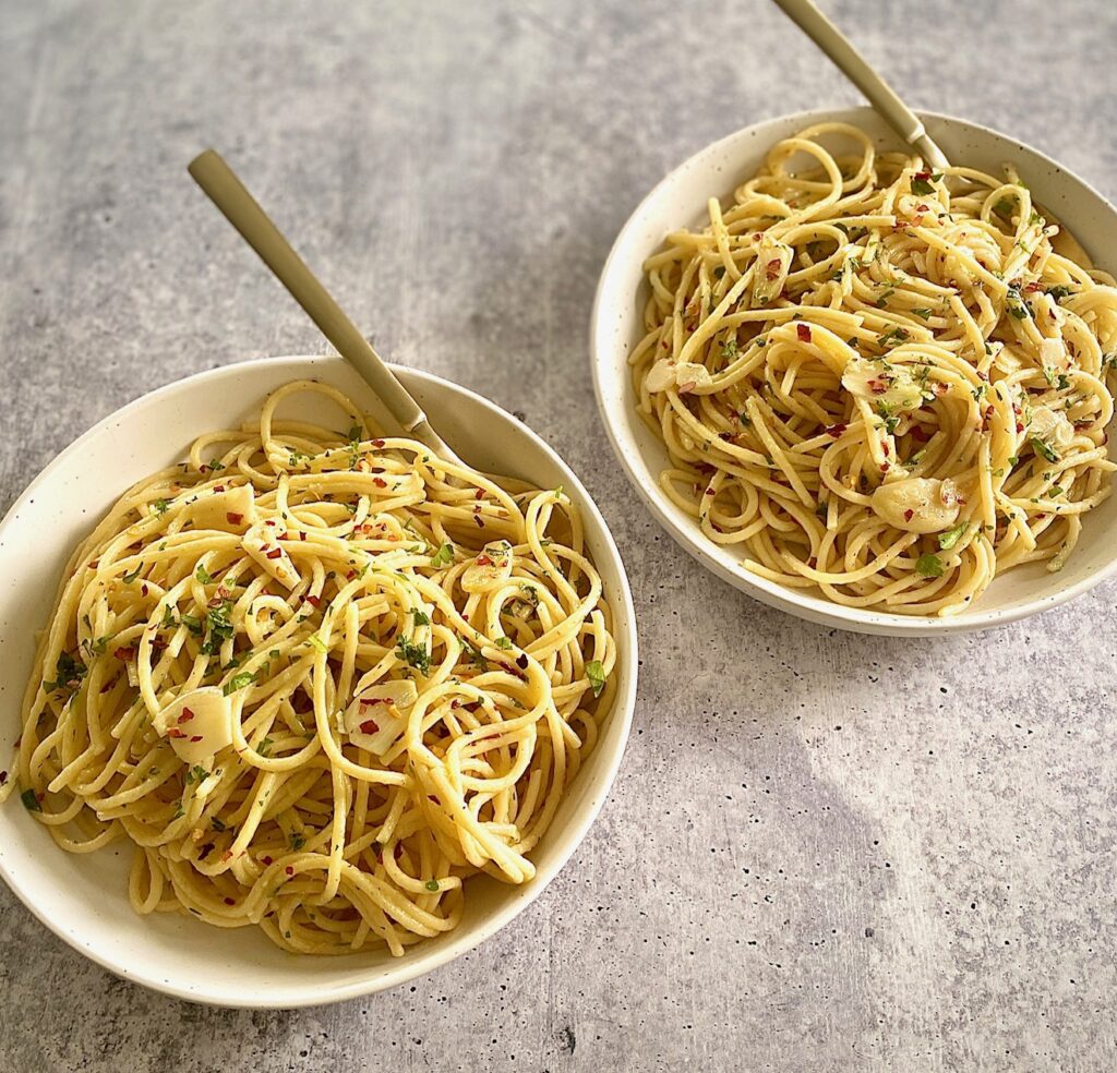 spaghetti garlic in 2 white bowls